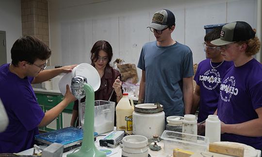 five young people at a table mixing materials